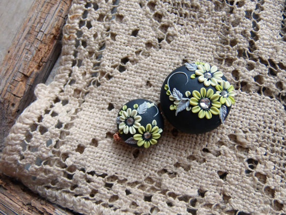 black bead set on an ebony background with floral in shades of kiwi and foliage in dove gray.