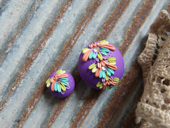 bead set on a true purple background, and floral design in shades of orange, kiwi green, and teal. 
