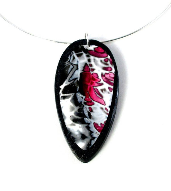 Original and modern polymer clay pendant mixing the black , red and white colors with beautiful iridescent reflections.