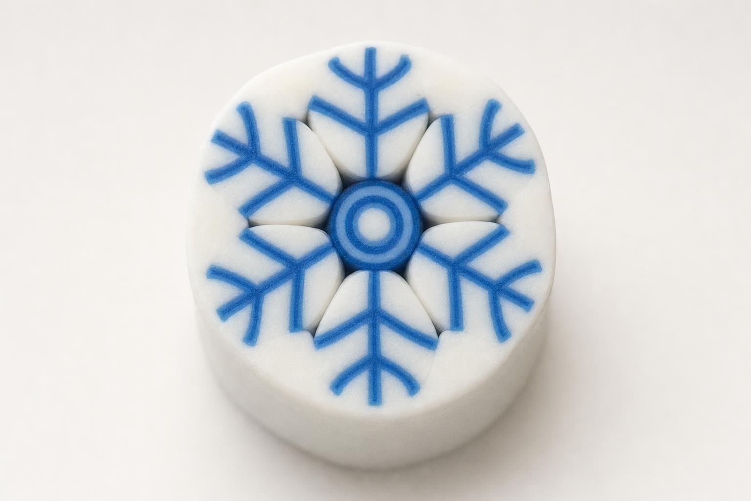Blue and white polymer clay snowflake cane showing the six-armed snowflake cross-section